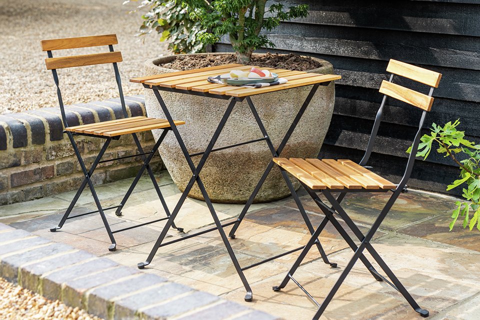 Habitat Eve 2 seater folding wooden garden bistro set placed outdoors.